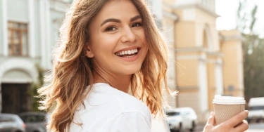 Blonde woman smiling with coffee