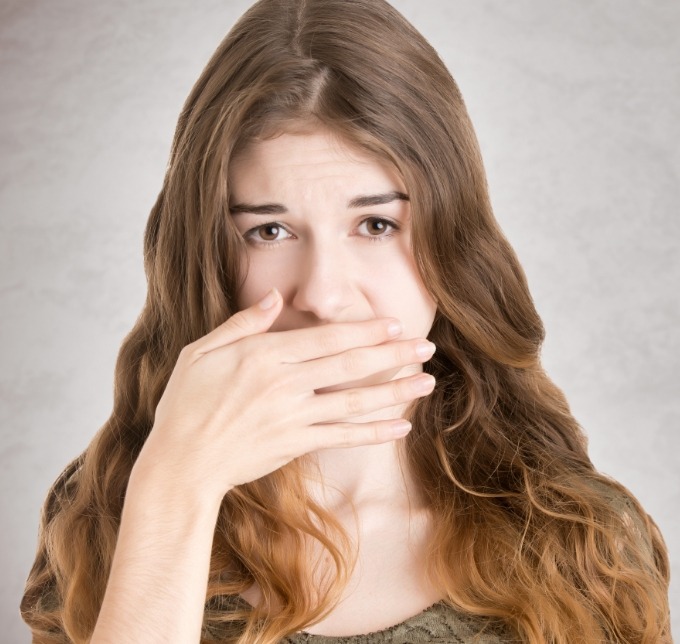 Woman with long hair covering her mouth